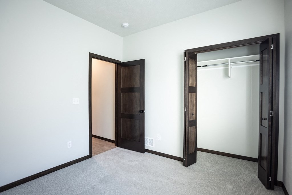 an empty room with a closet and a door to a wardrobe