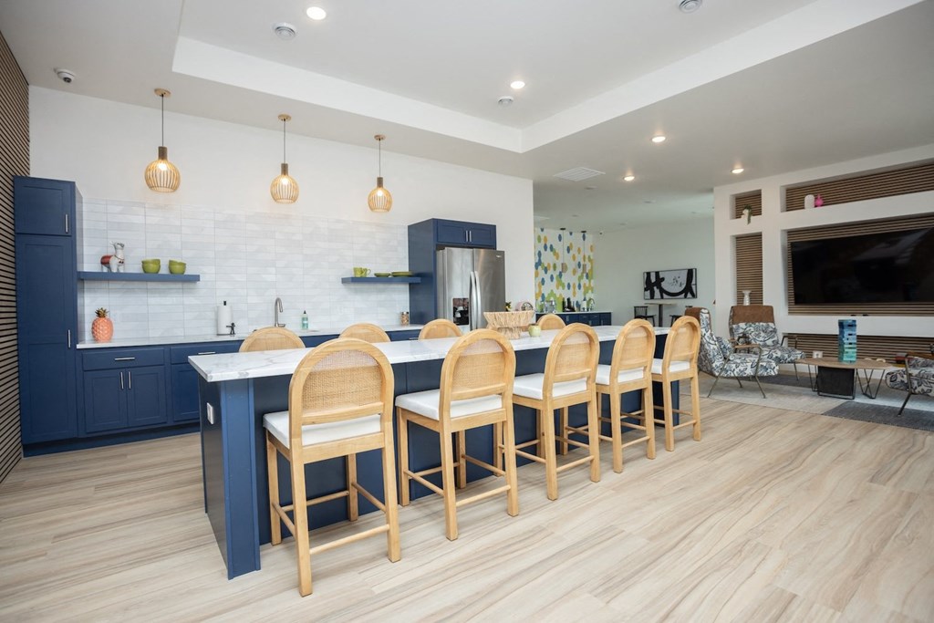 a large kitchen with a blue island and chairs in front of a dining table