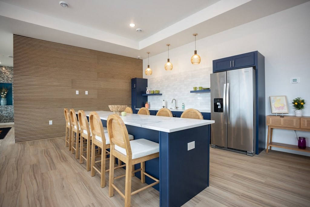 a kitchen with a blue island and wooden chairs