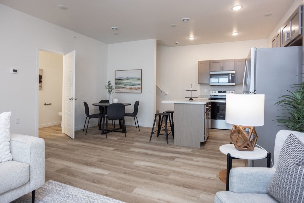 a living room and kitchen with a table and chairs
