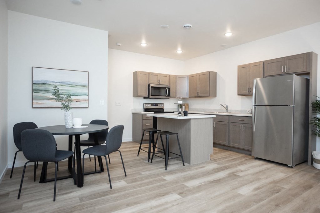 a kitchen and dining area with stainless steel appliances and a table and chairs