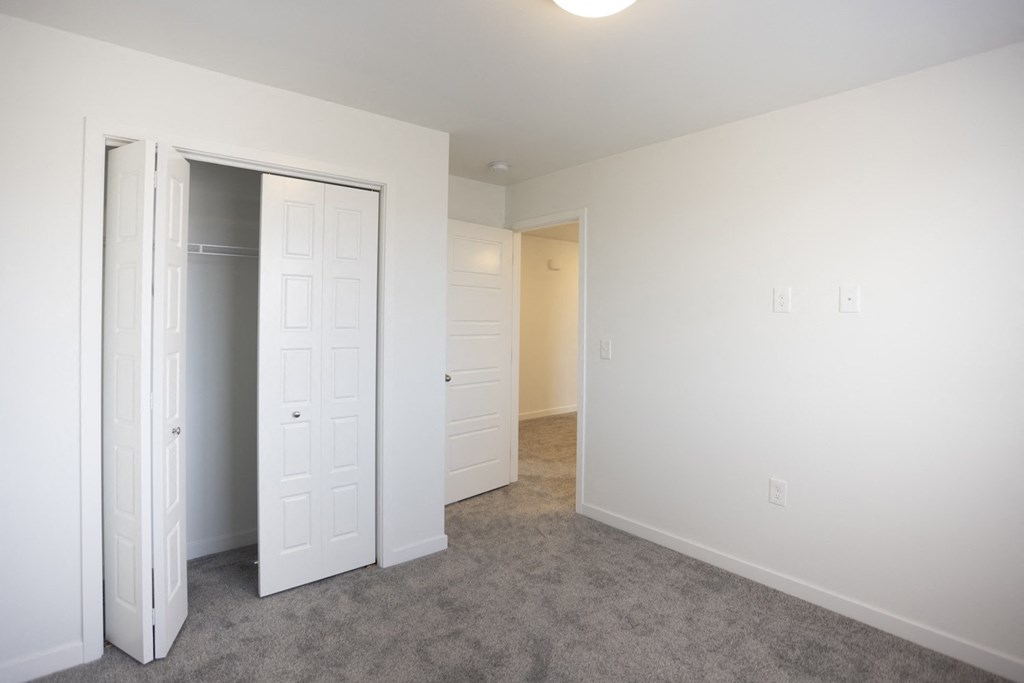 a bedroom with a closet and a mirrored closet door