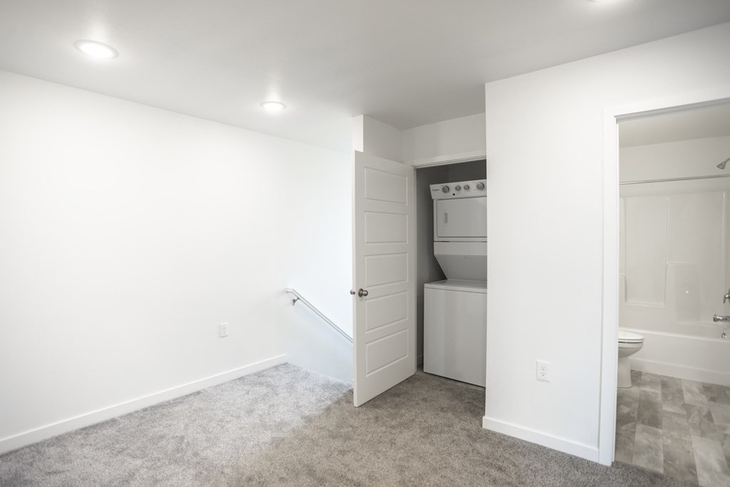 a white bathroom with a white door and a white toilet and sink