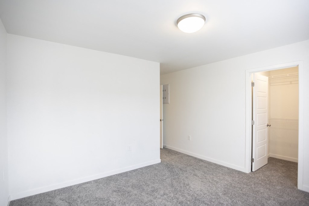 an empty room with white walls and a door to a closet