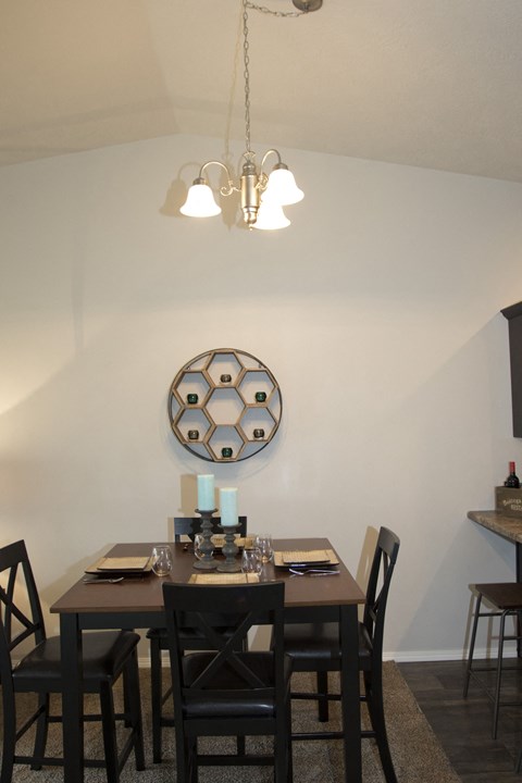 a dining room with a table and chairs and a mirror on the wall