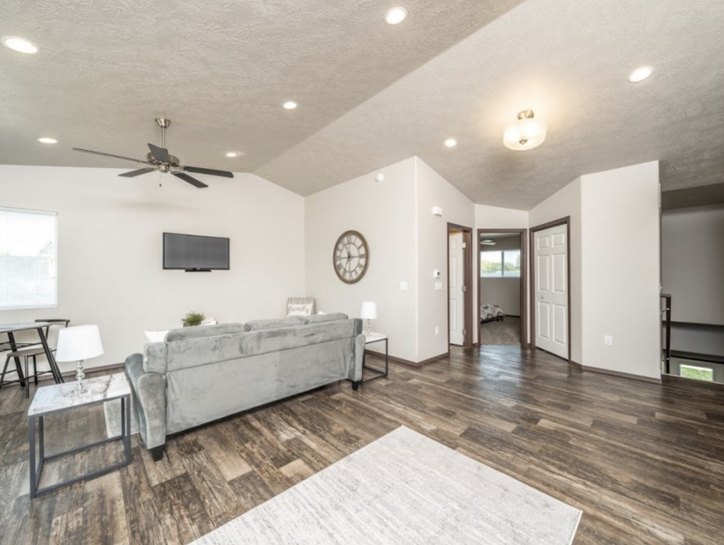 a living room with a couch and a ceiling fan