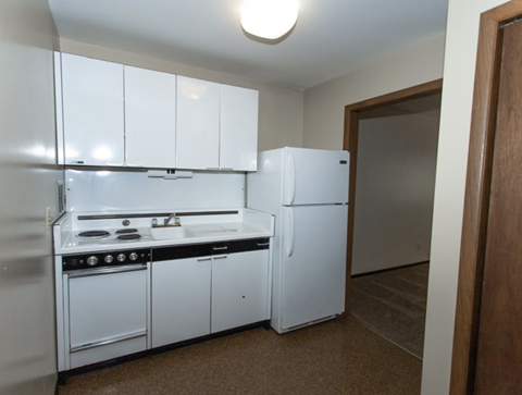 a kitchen with white appliances and a refrigerator