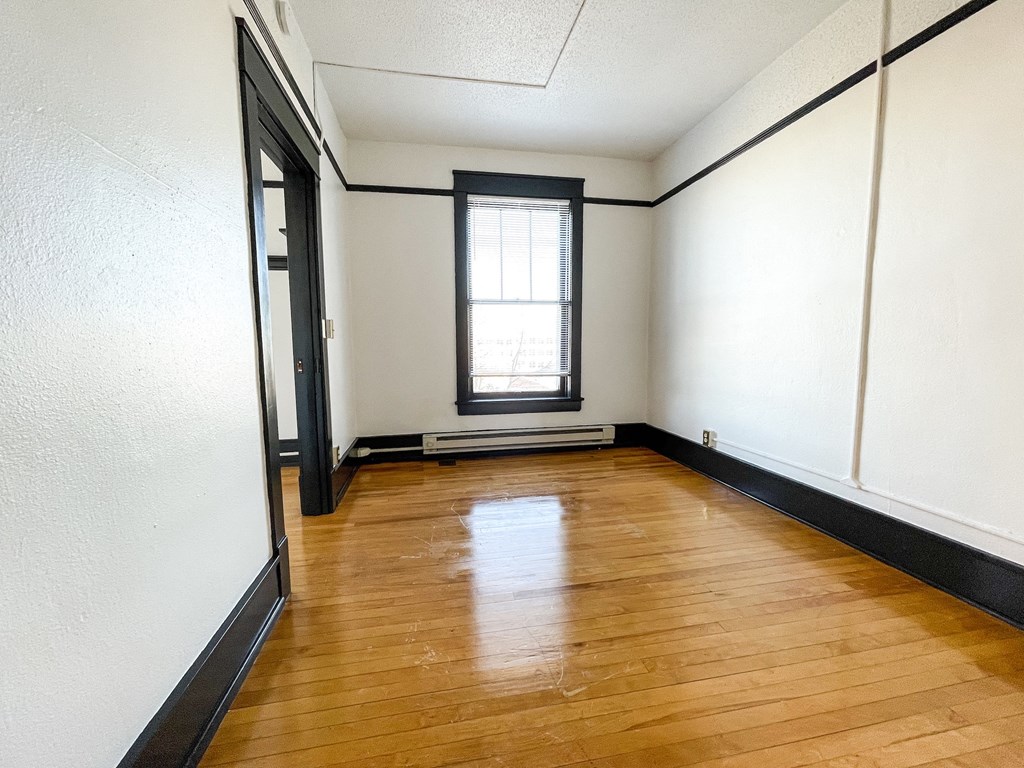 a empty room with wood floors and a window