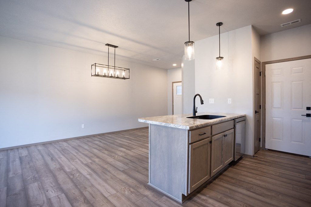 the kitchen and living room in a new home with white walls and wood floors