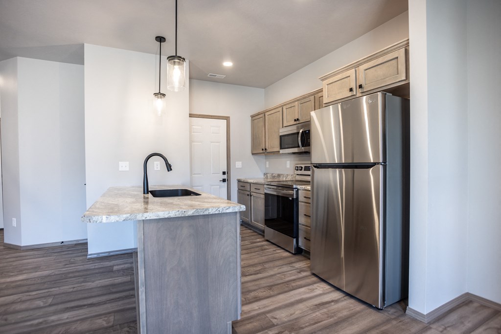 a kitchen with stainless steel appliances and a marble counter top