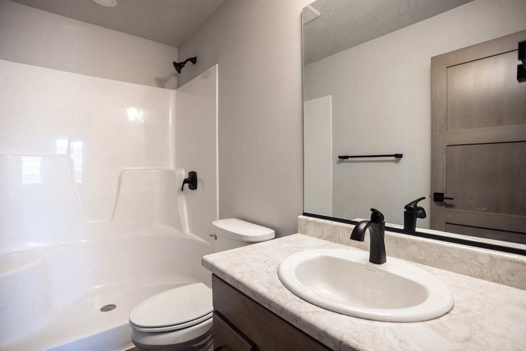 an empty bathroom with a sink and a toilet and a shower