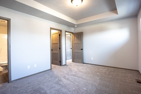 an empty living room with two doors and a white wall