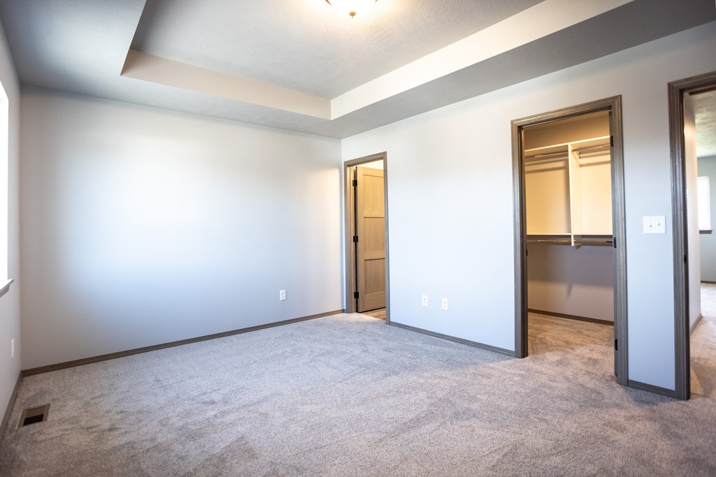 an empty living room with white walls and a door to a closet