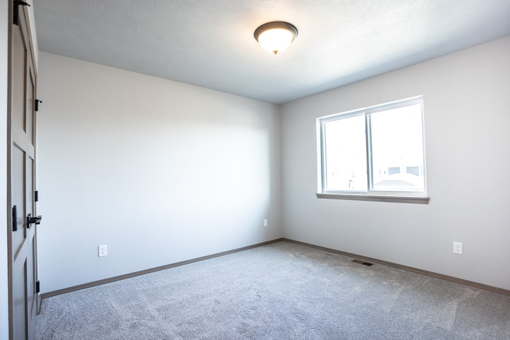 an empty room with a window and white walls