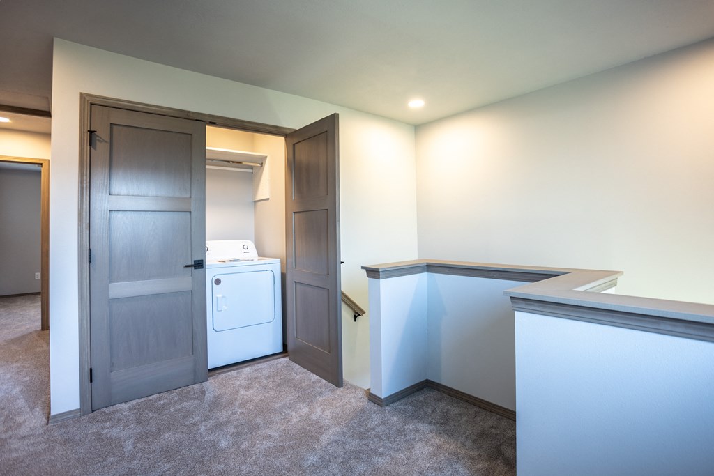 a laundry room with a washer and dryer and a door to a bathroom