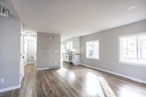 A spacious room with wooden floors and white walls.