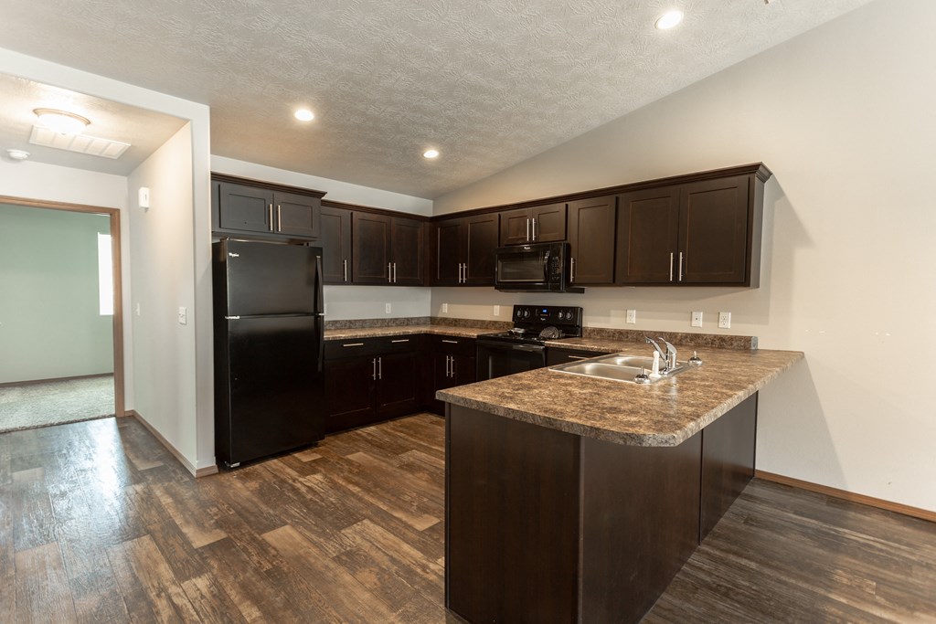 a kitchen with black appliances and a granite counter top
