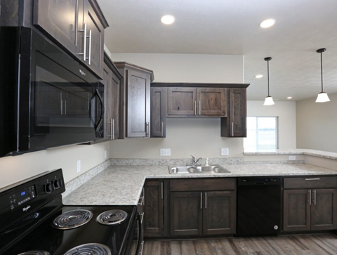 a kitchen with black appliances and wooden cabinets