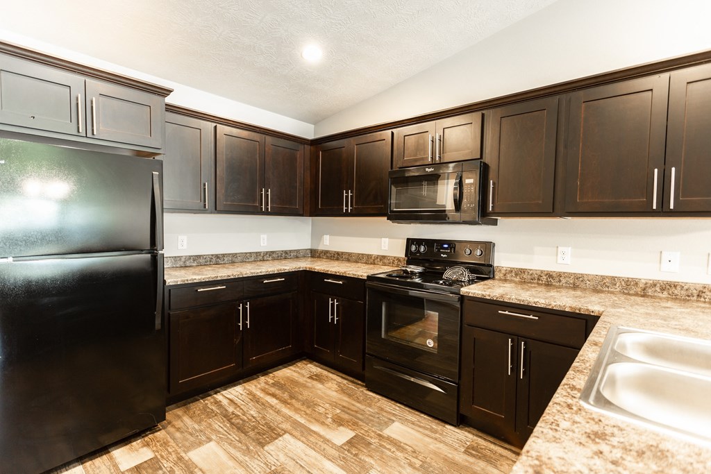 a kitchen with black appliances and granite counter tops