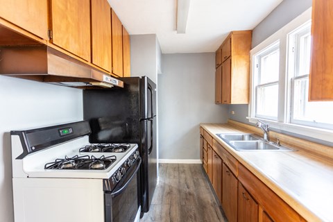 an empty kitchen with wooden cabinets and a stove and refrigerator