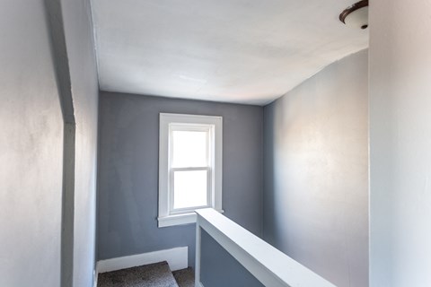 a room with blue walls and a window and a staircase