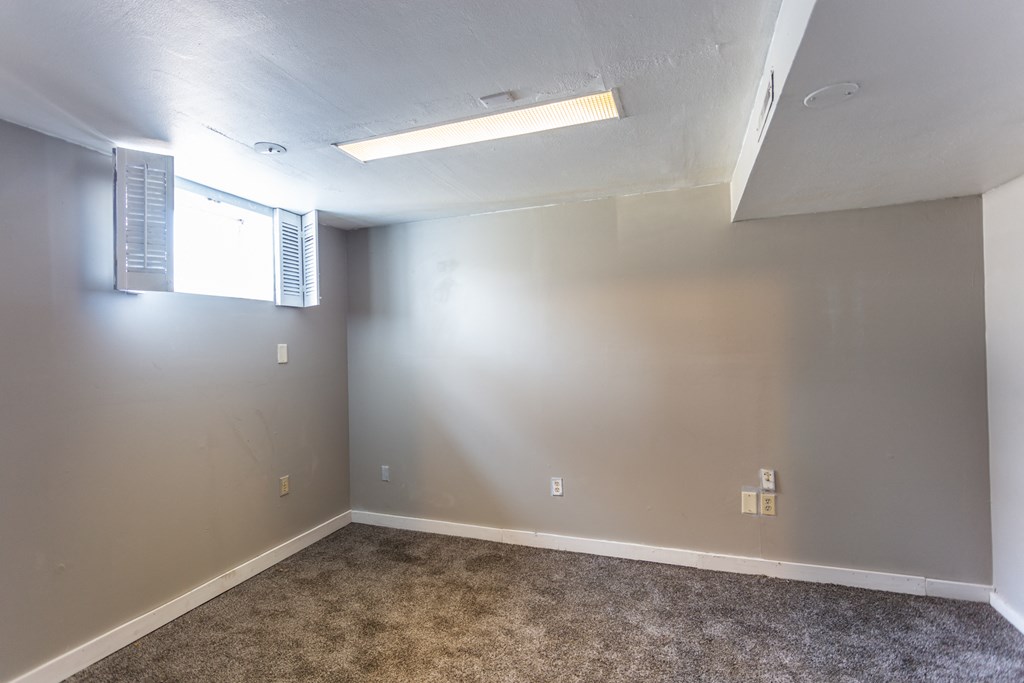 an empty room with grey walls and a window