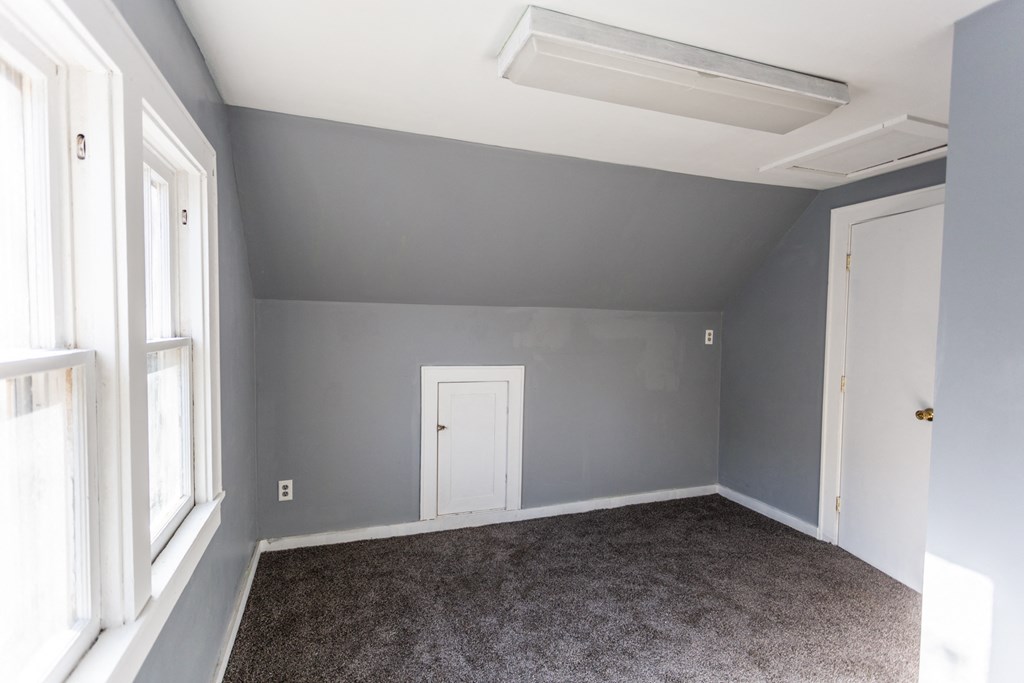 an empty room with grey walls and a white door