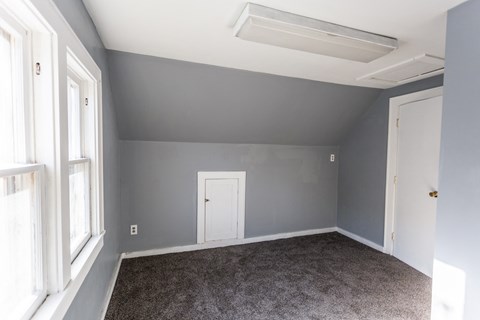 an empty room with grey walls and a white door