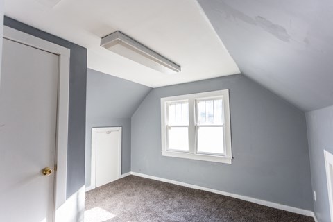 an empty room with a window and a door