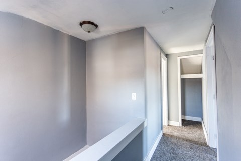 an empty room with white walls and a mirror on the wall