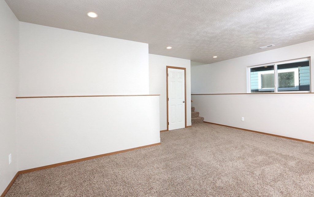 an empty living room with white walls and carpet