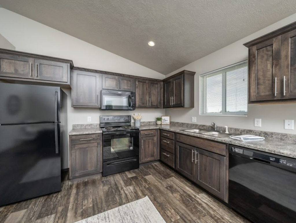 the kitchen of a home with dark cabinets and stainless steel appliances