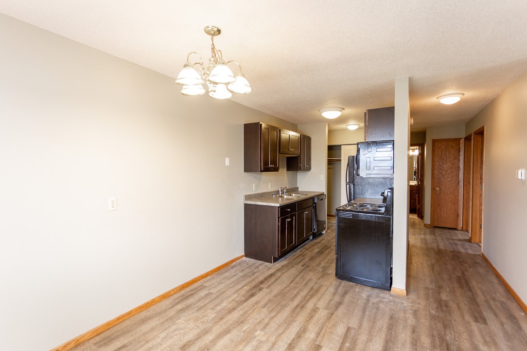 a kitchen and living room with a hardwood floor and a kitchen island with a