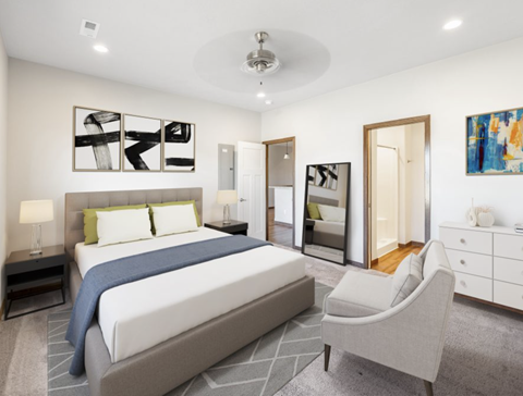 a white bedroom with a large bed and a chair