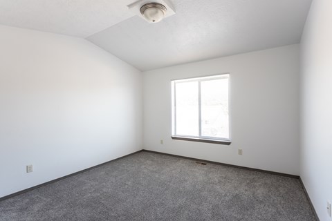 an empty room with white walls and a window