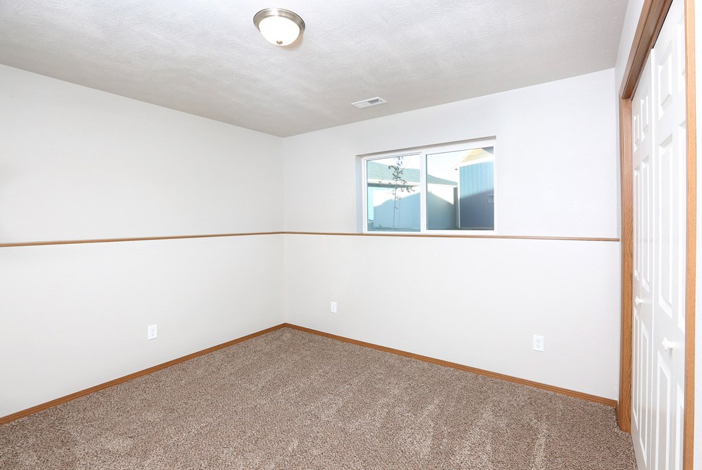 an empty room with carpet and a window
