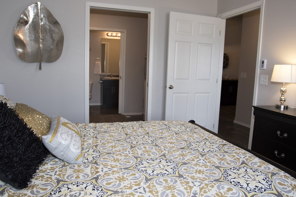 a bedroom with a large bed and a door to a bathroom