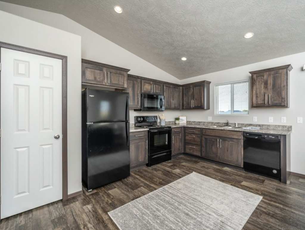 the kitchen of a home with black appliances and wooden cabinets
