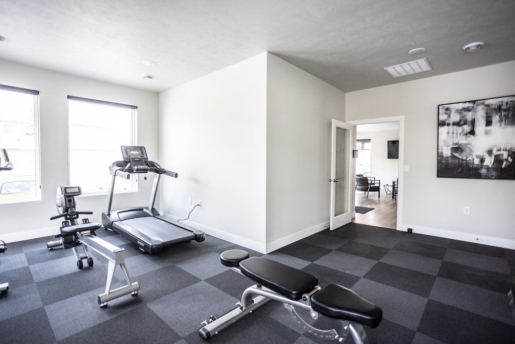 a gym with weights and a chair in the corner of a room