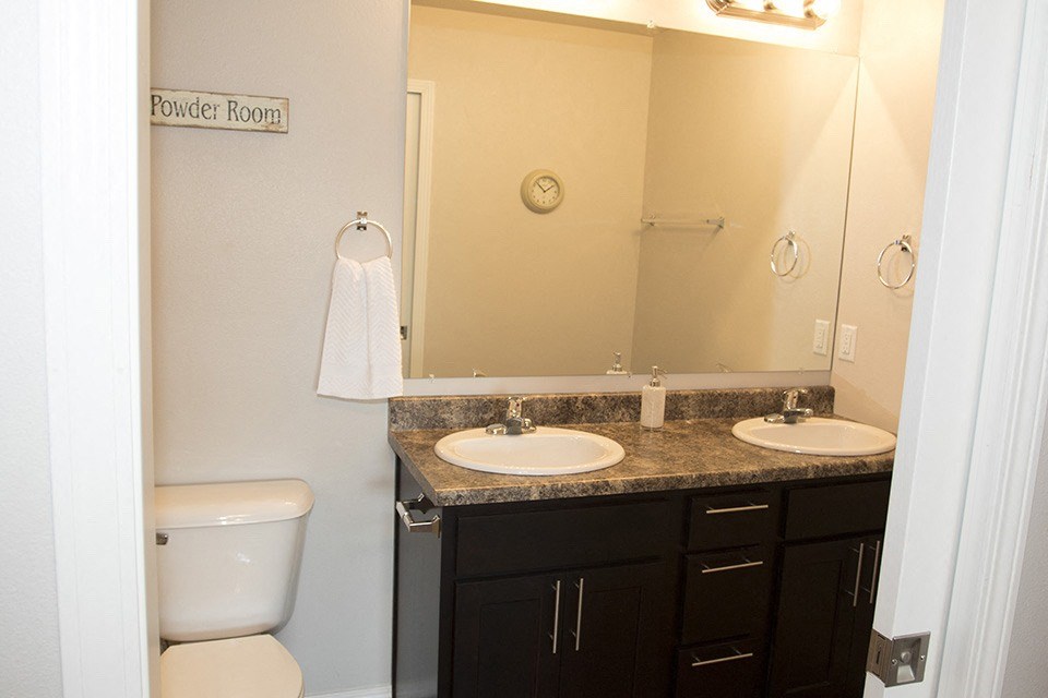 a bathroom with two sinks and a toilet and a mirror