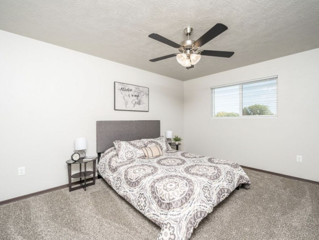 a bedroom with a bed and a ceiling fan