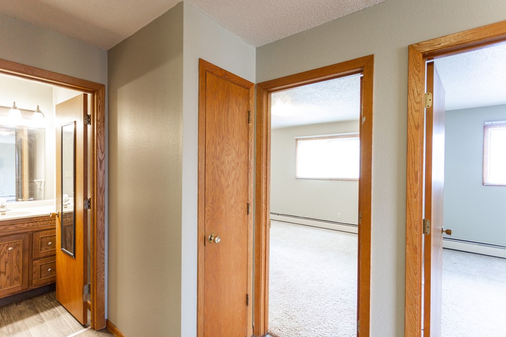 an empty room with two doors and a mirror in a house