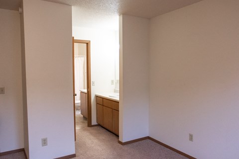 an empty room with a sink and a mirror in a house