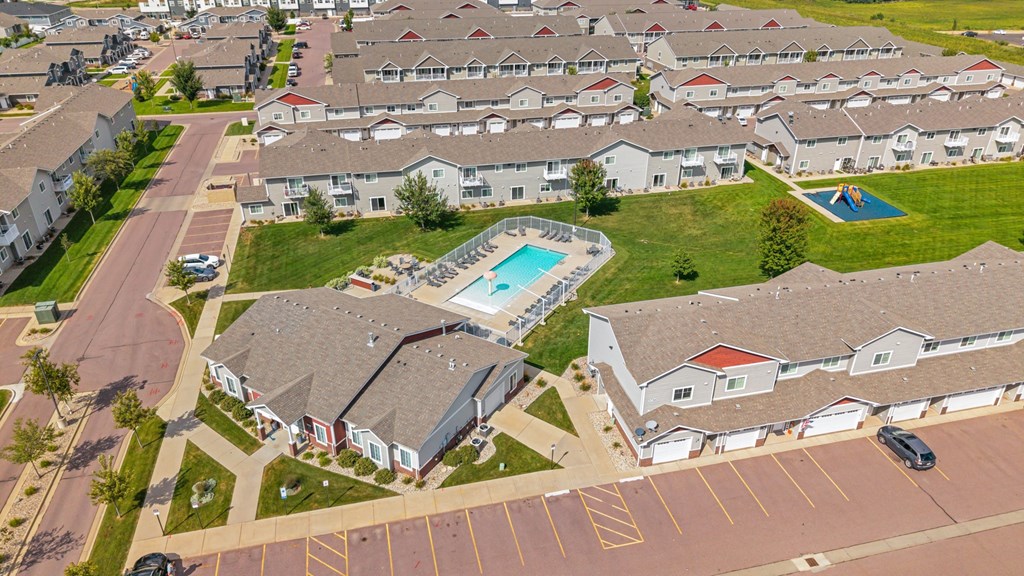 A swimming pool is surrounded by houses in a residential area.