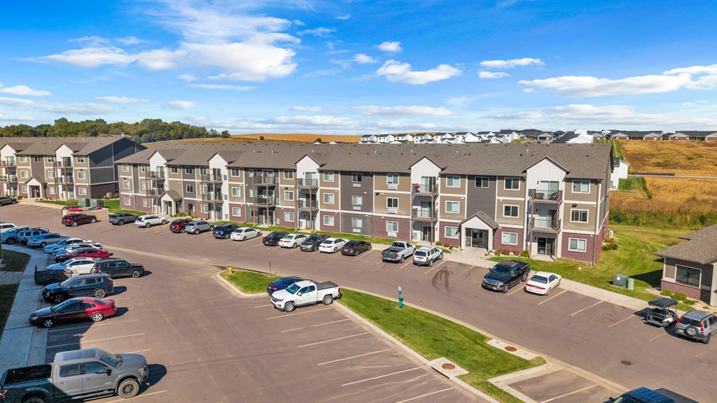 A parking lot in front of apartment buildings.