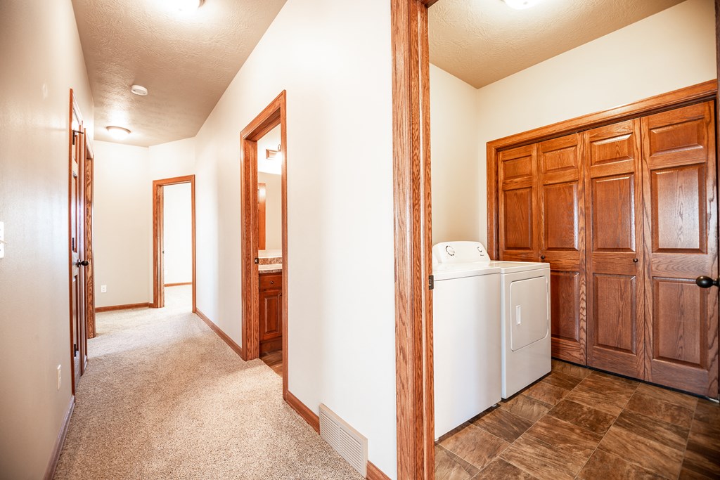 a laundry room with a washer and dryer and a door to a bathroom