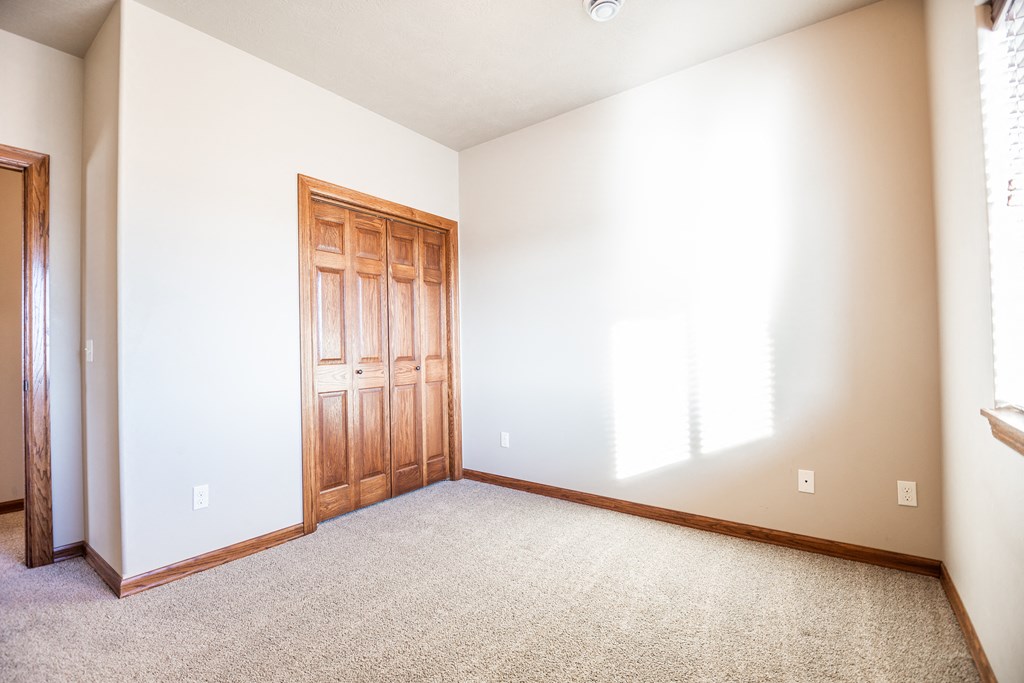 an empty room with a wooden door and carpet