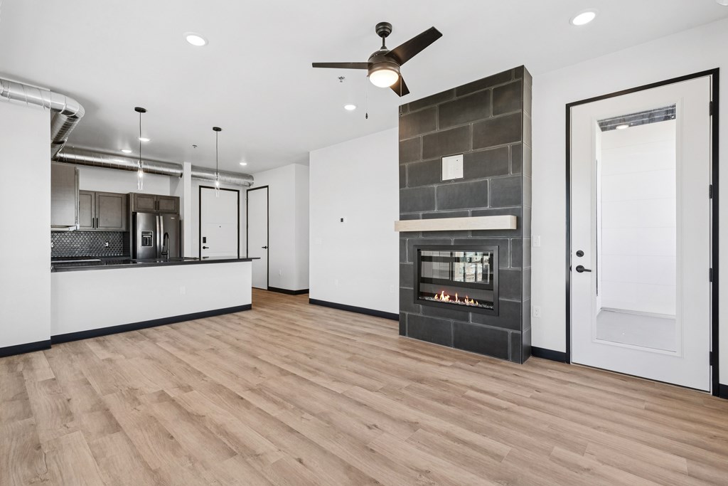 A modern kitchen with a wood floor and a fireplace.