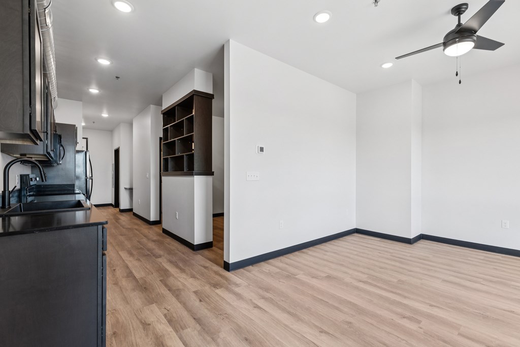 A modern kitchen with wooden floors and white walls.