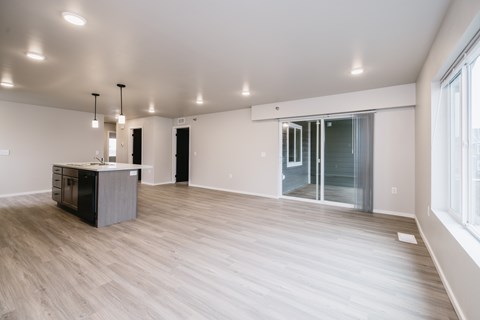 A spacious room with a wooden floor and a cabinet in the corner.